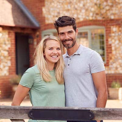 Arkansas couple in front of their house